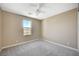 Cozy bedroom with neutral walls, plush carpet, a ceiling fan, and a view overlooking the city skyline at 3356 Dalmore St, Henderson, NV 89044