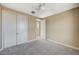 The bedroom has neutral walls, plush carpet, ceiling fan, and a closet with sleek sliding doors at 3356 Dalmore St, Henderson, NV 89044