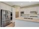 Well-lit kitchen with stainless appliances, large pantry, kitchen island, and white cabinets at 3356 Dalmore St, Henderson, NV 89044