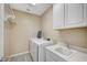 Bright laundry room with washer, dryer, cabinets, and a sink at 3356 Dalmore St, Henderson, NV 89044