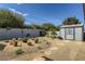 Desert landscaped backyard with cozy seating and a charming storage shed at 3543 Algonquin Dr, Las Vegas, NV 89169