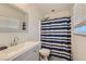 Bathroom with a shower/tub combo with a blue and white curtain, white sink and a window at 3543 Algonquin Dr, Las Vegas, NV 89169