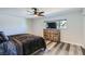 Cozy bedroom with a ceiling fan, a large window, and a wooden dresser and matching flooring at 3543 Algonquin Dr, Las Vegas, NV 89169