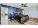 Blue accent wall in the bedroom with matching lamps and wood style flooring at 3543 Algonquin Dr, Las Vegas, NV 89169