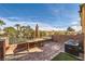 Outdoor patio with a brick surface, table and chairs, and lush green landscaping at 3558 Harbor Tides St, Las Vegas, NV 89147