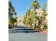 Scenic street lined with palm trees and lush greenery, leading towards mountain views at 3845 Wiggins Bay St # 104, Las Vegas, NV 89129