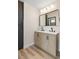 Bathroom featuring double vanity with black hardware, wood-look cabinets, and modern lighting at 3853 Kellogg Ave, Las Vegas, NV 89115