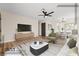 Modern living room with neutral tones, wood floors, ceiling fan and access to dining area at 3853 Kellogg Ave, Las Vegas, NV 89115