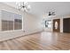 Open living room with wood-look floors, bright windows, and a modern ceiling fan at 3853 Kellogg Ave, Las Vegas, NV 89115