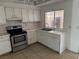 Functional kitchen with white cabinetry, stainless steel appliances, and tile countertops at 4770 Topaz St # 31, Las Vegas, NV 89121