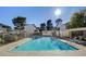 Community pool area with sunlit pool, shaded seating area, and white buildings at 4770 Topaz St # 31, Las Vegas, NV 89121