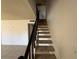 View of the staircase with carpeted steps and a dark metal handrail leading to the upper level of the home at 4770 Topaz St # 31, Las Vegas, NV 89121