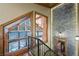 Hallway with ornate stairway, floor to ceiling stone wall, wood floors and timber framed windows at 4888 Snow White Rd, Las Vegas, NV 89124