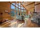 Bright living room with stone fireplace, wood paneling, and expansive windows overlooking the mountains at 4888 Snow White Rd, Las Vegas, NV 89124