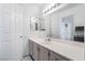 Bright bathroom with a large mirror, vanity with cabinets, and linen closet at 502 Fragrant Orchard St, Henderson, NV 89015