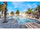 Community pool featuring brick patio, a variety of palm trees, and several lounge chairs at 502 Fragrant Orchard St, Henderson, NV 89015