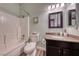 Compact bathroom with a combined shower and bathtub, a vanity with a dark wood finish, and patterned flooring at 52 Vallejo Verde St, Henderson, NV 89012