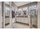 Bright bathroom featuring double sink vanity, framed mirrors, and a glass-enclosed shower with decorative tiling at 52 Vallejo Verde St, Henderson, NV 89012