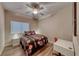 Cozy bedroom with a queen-sized bed, ceiling fan, window with blinds, and wood-look flooring at 52 Vallejo Verde St, Henderson, NV 89012