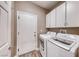 Laundry room features side-by-side washer and dryer and upper cabinets for storage at 52 Vallejo Verde St, Henderson, NV 89012