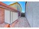 View of the side yard features a small storage shed, rock ground cover, and red brick and block retaining wall at 52 Vallejo Verde St, Henderson, NV 89012