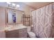 Traditional bathroom featuring a marble vanity, shower-tub combination, and a decorative shower curtain at 5399 Surrey St, Las Vegas, NV 89119