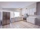 Spacious kitchen with tile flooring, white cabinets, stainless steel appliances, and a large window at 5399 Surrey St, Las Vegas, NV 89119