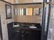 Bathroom featuring black cabinetry, double vanity, and shower with glass block accents at 5748 Spring Ranch Pkwy, Las Vegas, NV 89118