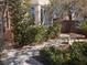 Landscaped front yard with lush greenery, mature trees, and a stone pathway leading to the entrance at 5748 Spring Ranch Pkwy, Las Vegas, NV 89118