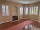 Bright living room with wood flooring, fireplace, fresh paint, and abundant natural light from large windows at 5748 Spring Ranch Pkwy, Las Vegas, NV 89118