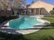 Lush backyard featuring a pool and stone patio, ideal for relaxation and outdoor entertainment at 5748 Spring Ranch Pkwy, Las Vegas, NV 89118