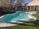 Inviting backyard pool with stone surround and lush, well-maintained artificial turf at 5748 Spring Ranch Pkwy, Las Vegas, NV 89118