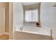 Bathroom featuring a soaking tub with white tile surround and a window at 6028 Stern Cove Ct, North Las Vegas, NV 89031