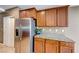 Spacious kitchen featuring stainless steel refrigerator, granite countertops, and wood cabinets at 6028 Stern Cove Ct, North Las Vegas, NV 89031