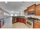 Open kitchen featuring stainless steel appliances, breakfast bar, wood cabinets and tile floors at 6028 Stern Cove Ct, North Las Vegas, NV 89031