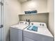 Bright laundry room with appliances and a storage shelf at 6164 Aster Garden St # 137, North Las Vegas, NV 89081