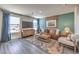 Bright living room featuring wood floors, a large window and television at 6164 Aster Garden St # 137, North Las Vegas, NV 89081