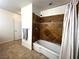 Cozy bathroom with stylish tile shower and soaking tub with neutral-toned tile flooring at 628 Avenue L, Boulder City, NV 89005