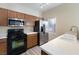 Kitchen showing stainless steel appliances, wood cabinets and white countertops at 6317 Beige Bluff St # 3, North Las Vegas, NV 89081