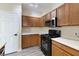 Cozy kitchen featuring wooden cabinets, black appliances, and a white countertop at 6317 Beige Bluff St # 3, North Las Vegas, NV 89081