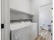 Well-lit laundry room with white washer, dryer, and wire shelving at 6317 Beige Bluff St # 3, North Las Vegas, NV 89081