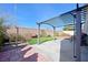 Backyard featuring a pergola over concrete, artificial grass, and rock landscaping and a brick perimeter at 6329 Aloha Sue St, North Las Vegas, NV 89031