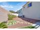 Low maintenance backyard featuring rock landscaping, a small patch of artificial turf and a brick perimeter at 6329 Aloha Sue St, North Las Vegas, NV 89031