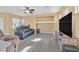 Comfortable living room featuring gray flooring, and a large display cabinet with a large tv screen at 6329 Aloha Sue St, North Las Vegas, NV 89031