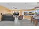 Open-concept living room with gray flooring, comfortable seating, a ceiling fan, and an entertainment center at 6329 Aloha Sue St, North Las Vegas, NV 89031