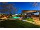 A well-manicured backyard featuring an inviting pool with a rock waterfall and a shaded pergola with lounge seating at 6689 Sparks Ave, Las Vegas, NV 89142
