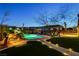 Lush backyard featuring a pristine pool and spa, along with an elegant outdoor lighting and patio area at 6689 Sparks Ave, Las Vegas, NV 89142