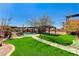 Landscaped backyard featuring a pool, covered seating, and artificial turf at 6689 Sparks Ave, Las Vegas, NV 89142