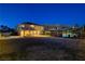 Expansive backyard featuring a pool, covered patio, and mountain views at twilight at 6689 Sparks Ave, Las Vegas, NV 89142