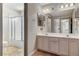 Bright bathroom with a double sink vanity, glass shower, and beige tile flooring at 6689 Sparks Ave, Las Vegas, NV 89142